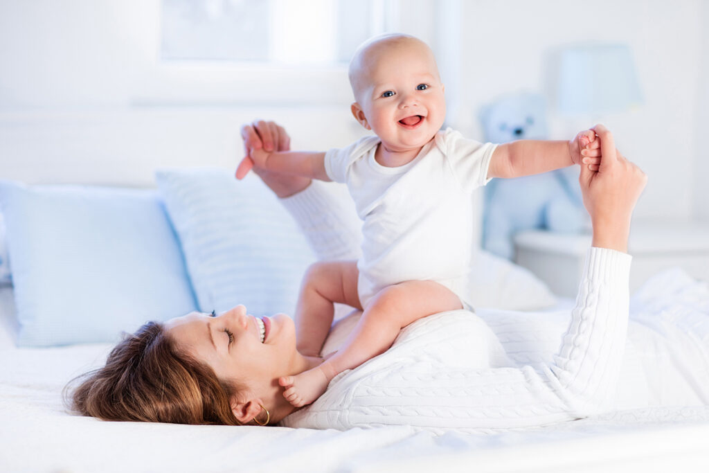 Mother and baby on a white bed