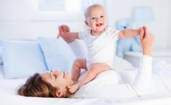 Mother and baby on a white bed