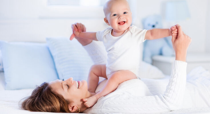 Mother and baby on a white bed